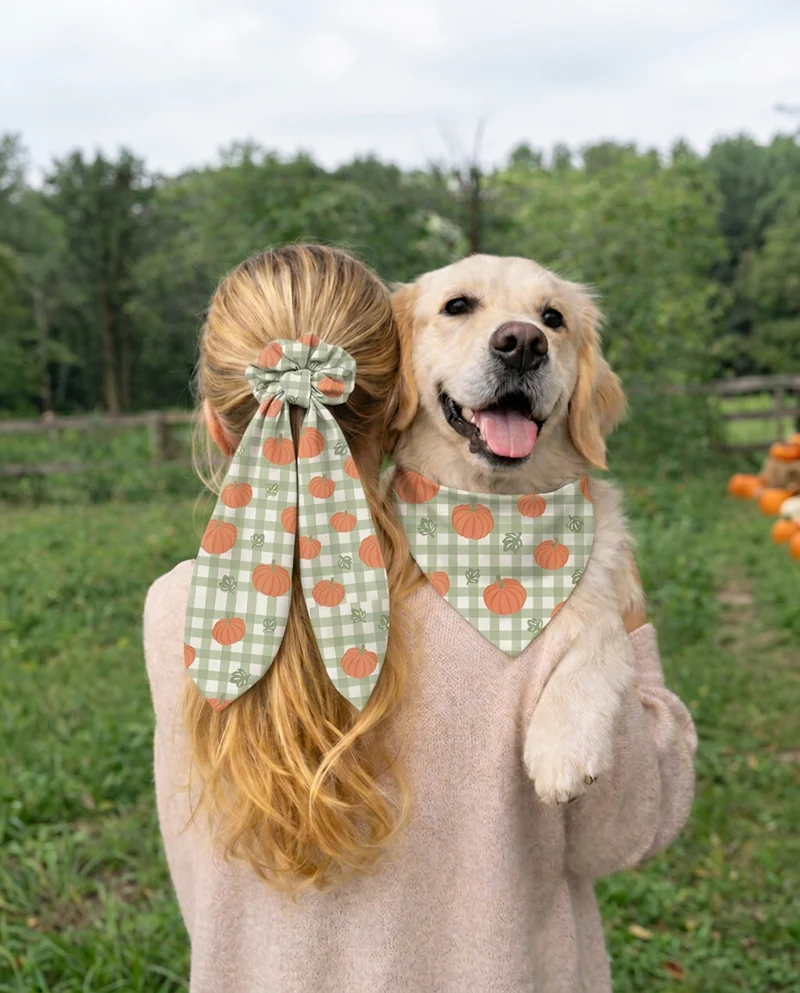 A matching scrunchie and bandana set, worn by a woman and her dog
